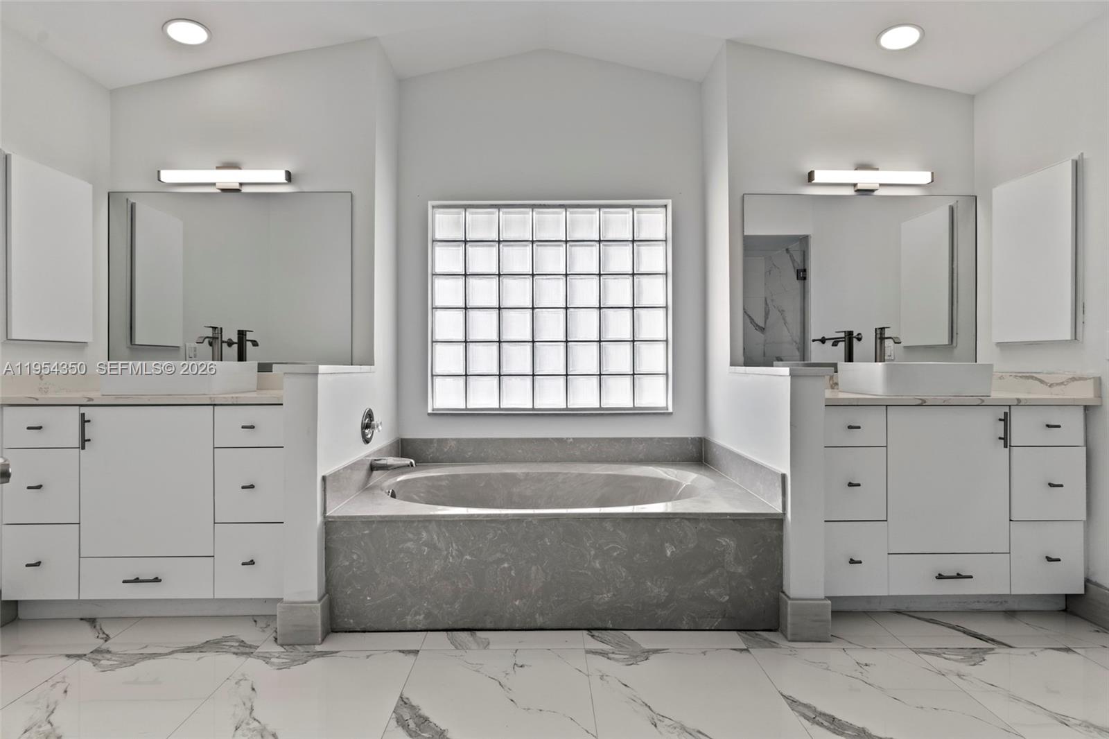 6357 Brava Way, Unit 6357 Boca Raton, FL 33433 - Photo 27 of 45 A luxurious bathroom, with its gleaming finishes and soothing warmth, offers a tranquil retreat of unparalleled comfort.