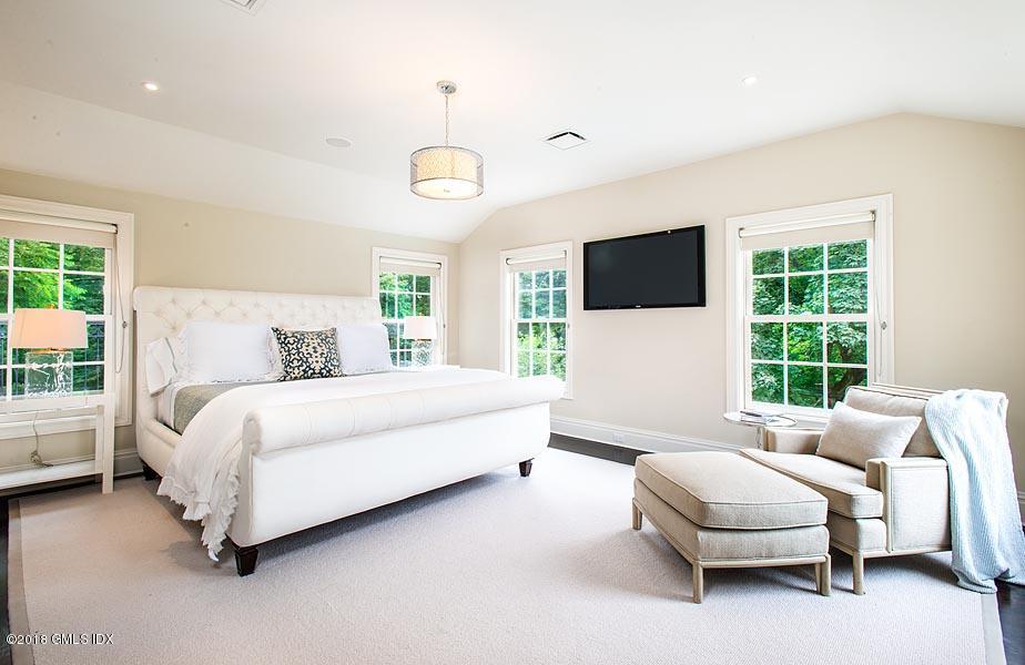 2 Round Hill Road Greenwich, CT 06831 - Photo 17 of 34 a spacious bedroom with a bed and a flat screen tv