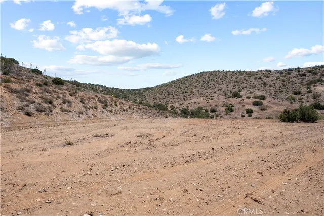 a view of a dry yard with mountains in the background