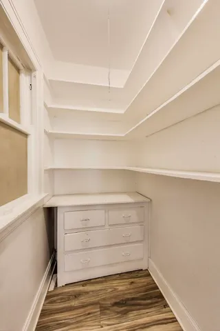 a view of a hallway with wooden floor and a living room