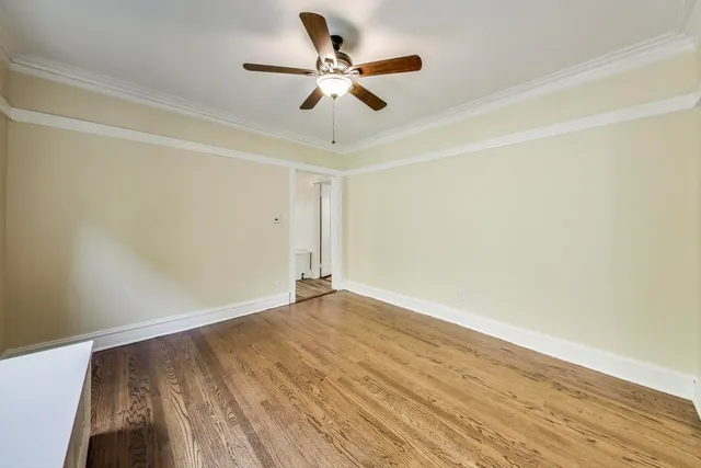 a view of an empty room with window and wooden floor
