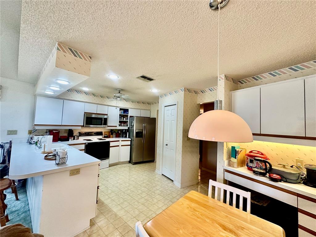 262 Santa Rosa Drive Winter Haven, FL 33884 - Photo 12 of 40 a kitchen with stainless steel appliances kitchen island granite countertop a sink a stove and a wooden floors