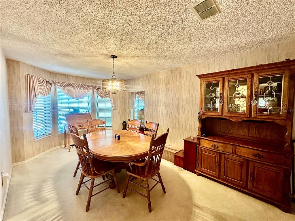 262 Santa Rosa Drive Winter Haven, FL 33884 - Photo 7 of 40 a dining room with furniture a chandelier and wooden floor