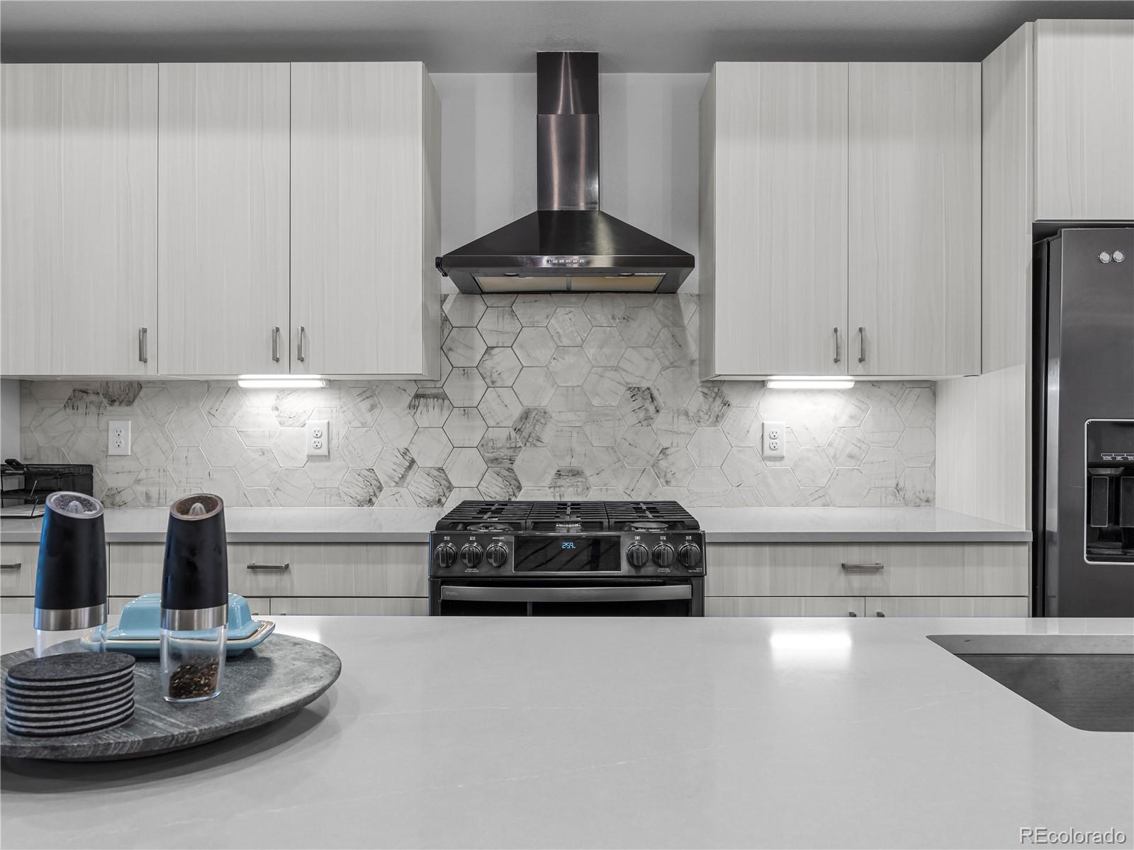 2350 Tremont Place, Unit 6 Denver, CO 80205 - Photo 15 of 40 a kitchen with granite countertop a stove a sink and a white cabinets