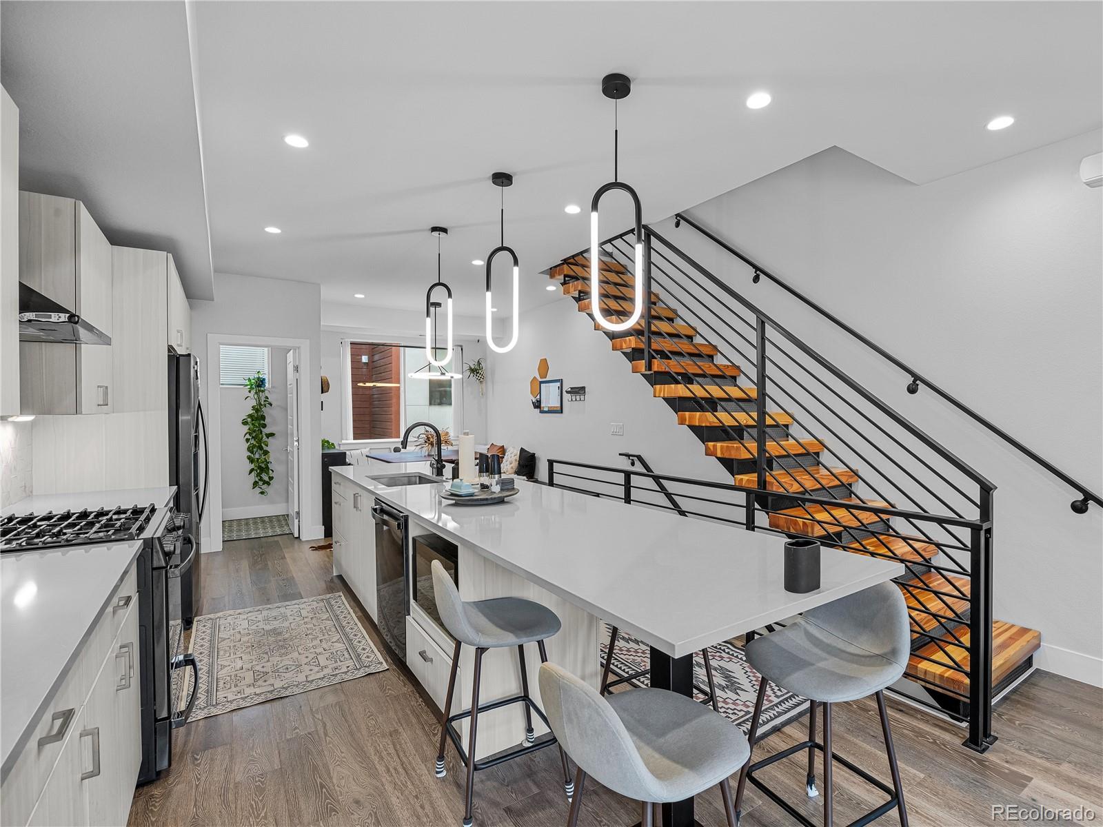 2350 Tremont Place, Unit 6 Denver, CO 80205 - Photo 20 of 40 a kitchen with stainless steel appliances kitchen island a stove a sink and a refrigerator