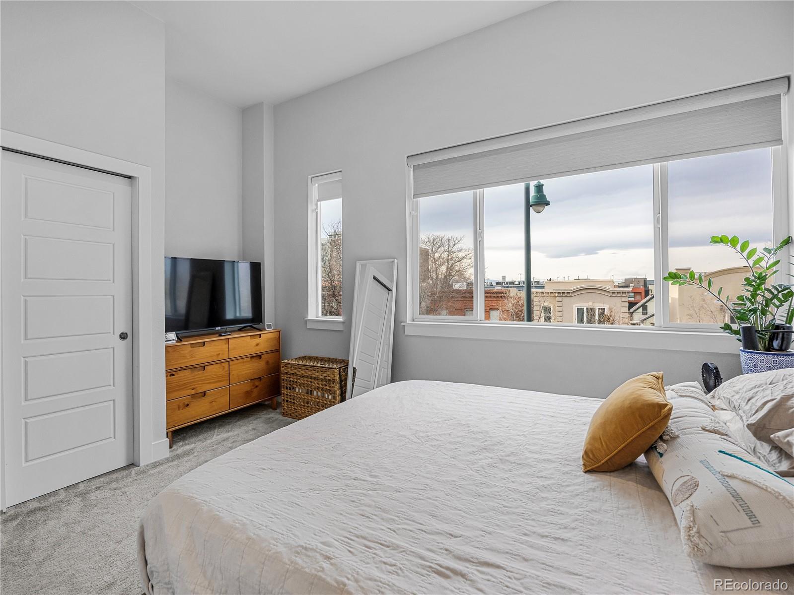2350 Tremont Place, Unit 6 Denver, CO 80205 - Photo 24 of 40 a bedroom with a bed and a large window