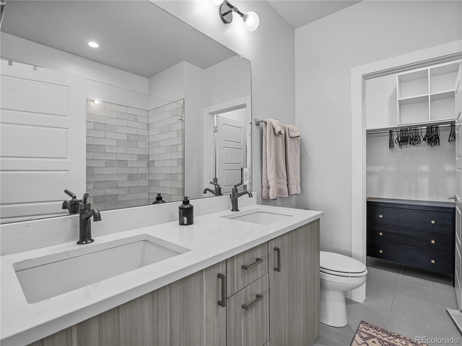 2350 Tremont Place, Unit 6 Denver, CO 80205 - Photo 25 of 40 a bathroom with a double vanity sink and a toilet