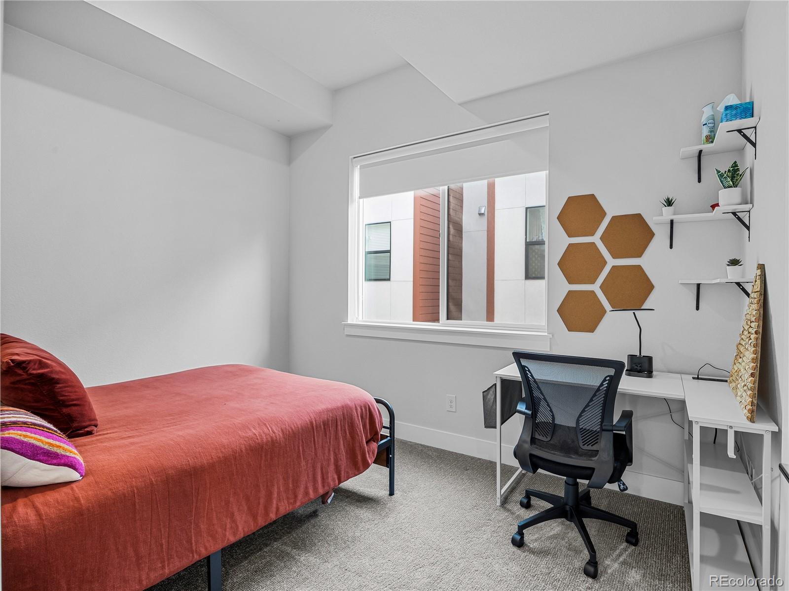 2350 Tremont Place, Unit 6 Denver, CO 80205 - Photo 28 of 40 a bedroom with a bed and a chair