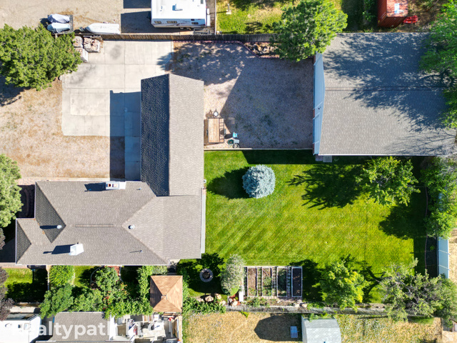 475 South 300 East Payson, UT 84651 - Photo 4 of 12 Expansive grassy yard area featuring a central evergreen shrub, mature trees, and raised garden beds
