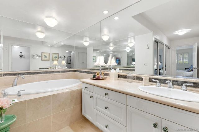 a spacious bathroom with a granite countertop sink mirror and bathtub