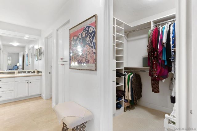 a view of walk in closet with clothes and shoes