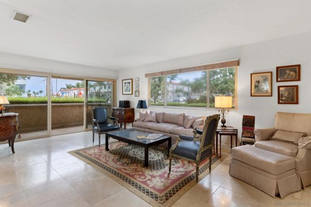a living room with furniture a large window and a table