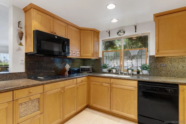 a kitchen with stainless steel appliances granite countertop a sink a stove and cabinets