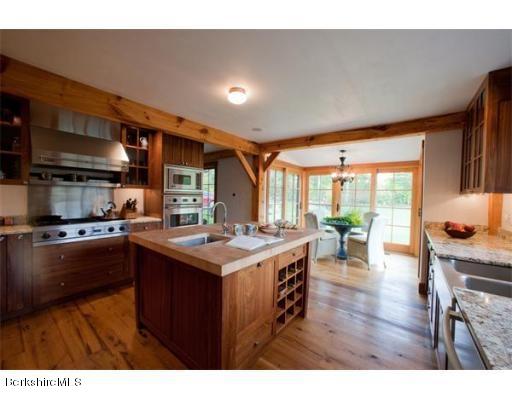 26 S Road Heath, MA 01346 - Photo 7 of 29 a kitchen with a stove a refrigerator and a dining table with wooden floor