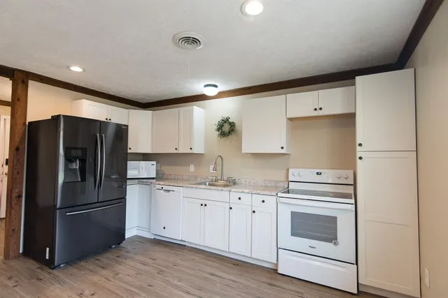 a kitchen with a refrigerator sink and cabinets
