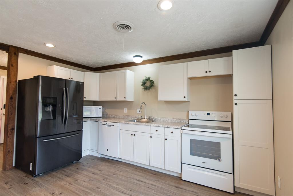 2501 Park Street Commerce, TX 75428 - Photo 2 of 24 a kitchen with a refrigerator sink and cabinets