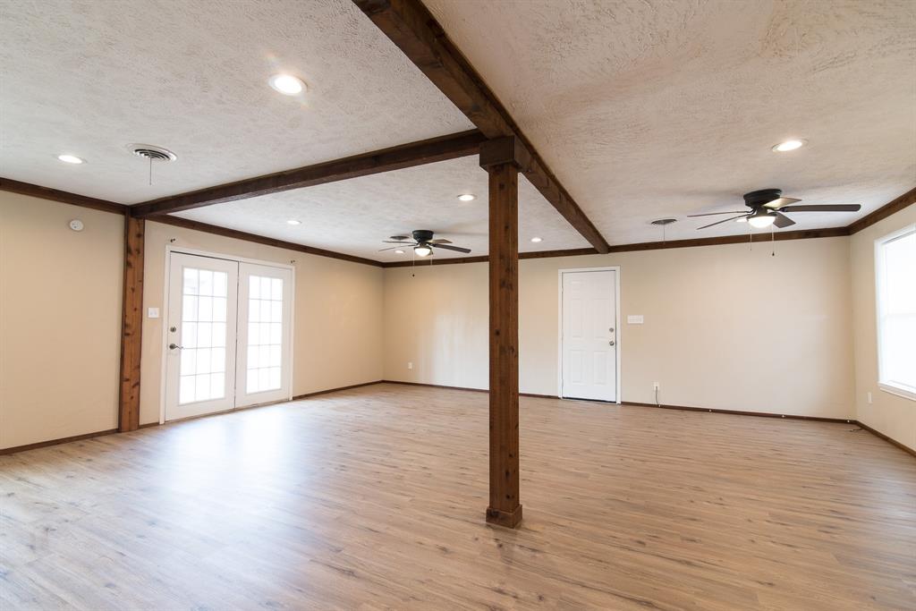 2501 Park Street Commerce, TX 75428 - Photo 3 of 24 a view of an empty room with wooden floor and a window