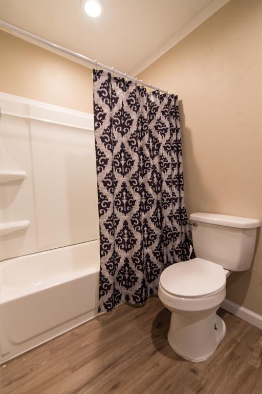 2501 Park Street Commerce, TX 75428 - Photo 7 of 24 a bathroom with a toilet and a shower curtain