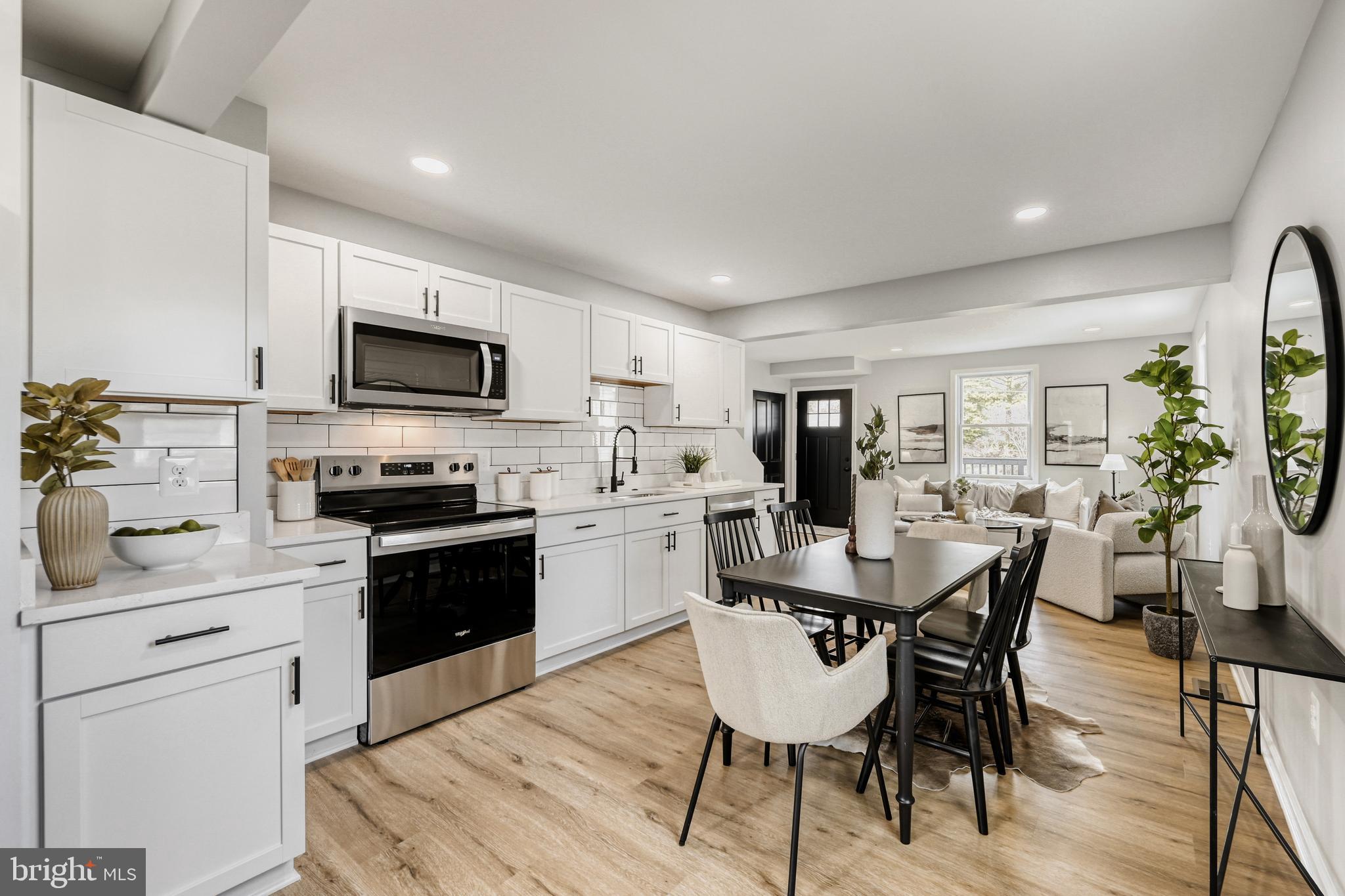 39 Transverse Avenue Middle River, MD 21220 - Photo 9 of 29 a kitchen with stainless steel appliances kitchen island granite countertop a sink dishwasher a stove a refrigerator a dining table and chairs with wooden floor