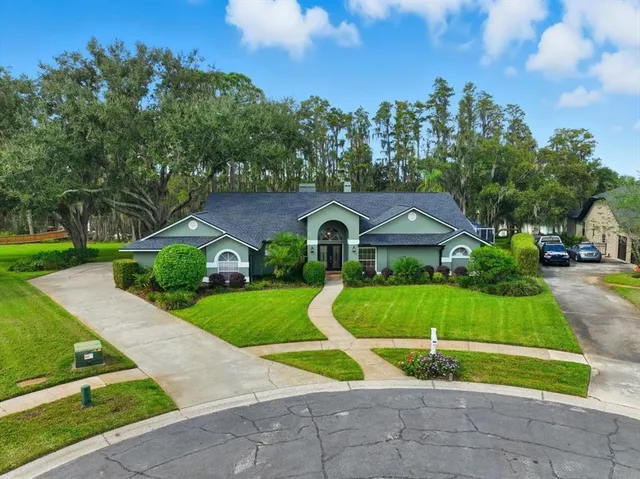an aerial view of a house with a yard and lake view