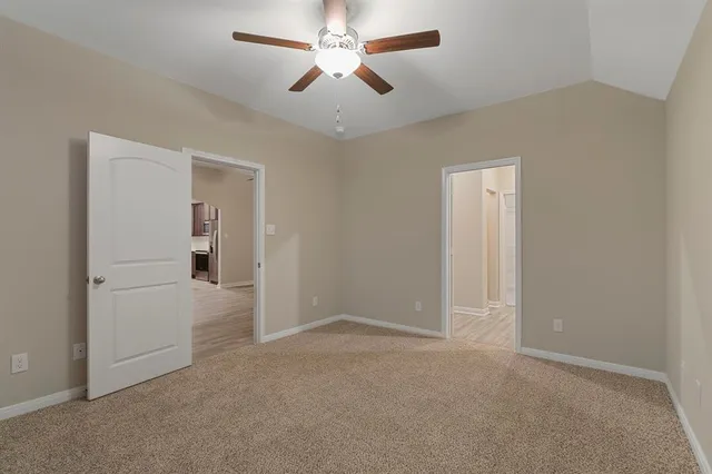 an empty room with chandelier fan