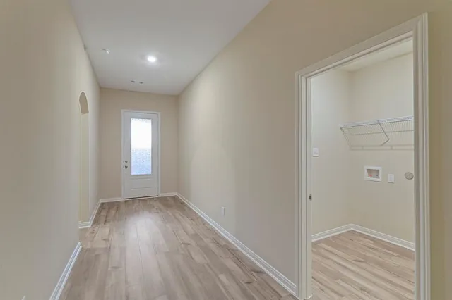 a view of hallway with a window and wooden floor