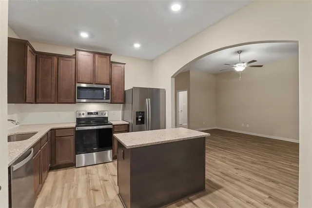 a kitchen with stainless steel appliances a refrigerator stove microwave and sink