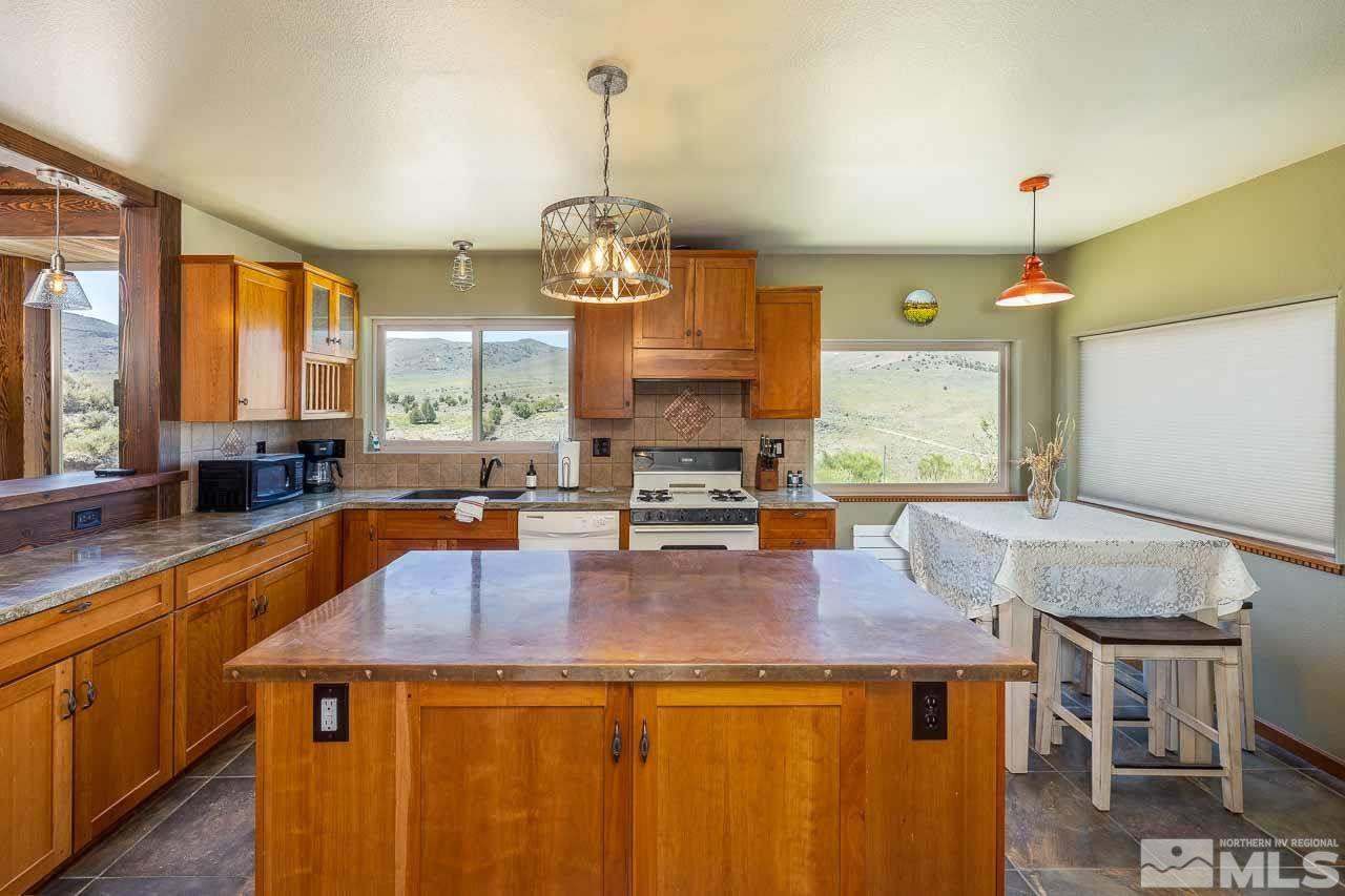 3415 Basque Oven Road Reno, NV 89510 - Photo 20 of 32 a kitchen with a stove a sink a counter space and living room view