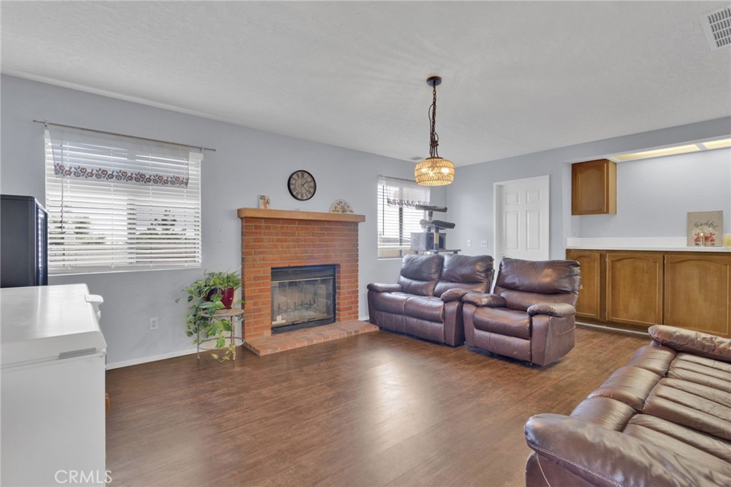 9224 Beekley Road Phelan, CA 92371 - Photo 14 of 52 a living room with furniture a fireplace and a flat screen tv