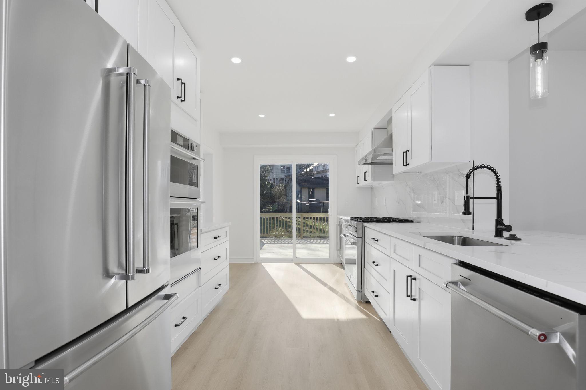a large kitchen with kitchen island a sink a stove and a window
