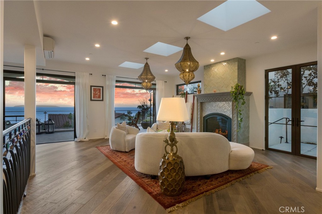 825 Coast View Drive Laguna Beach, CA 92651 - Photo 8 of 63 a living room with furniture wooden floor and a fireplace