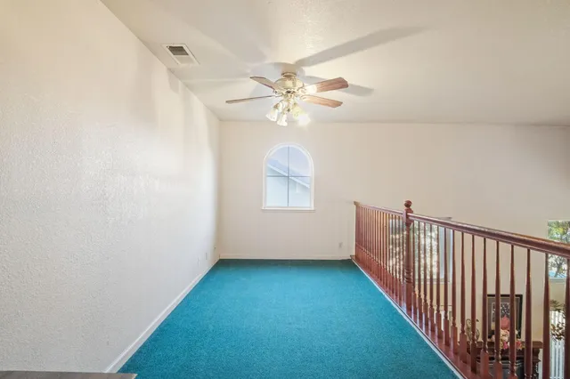 a view of a hallway with a window and a chandelier fan