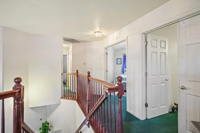 a view of a hallway with a white walls and stairs