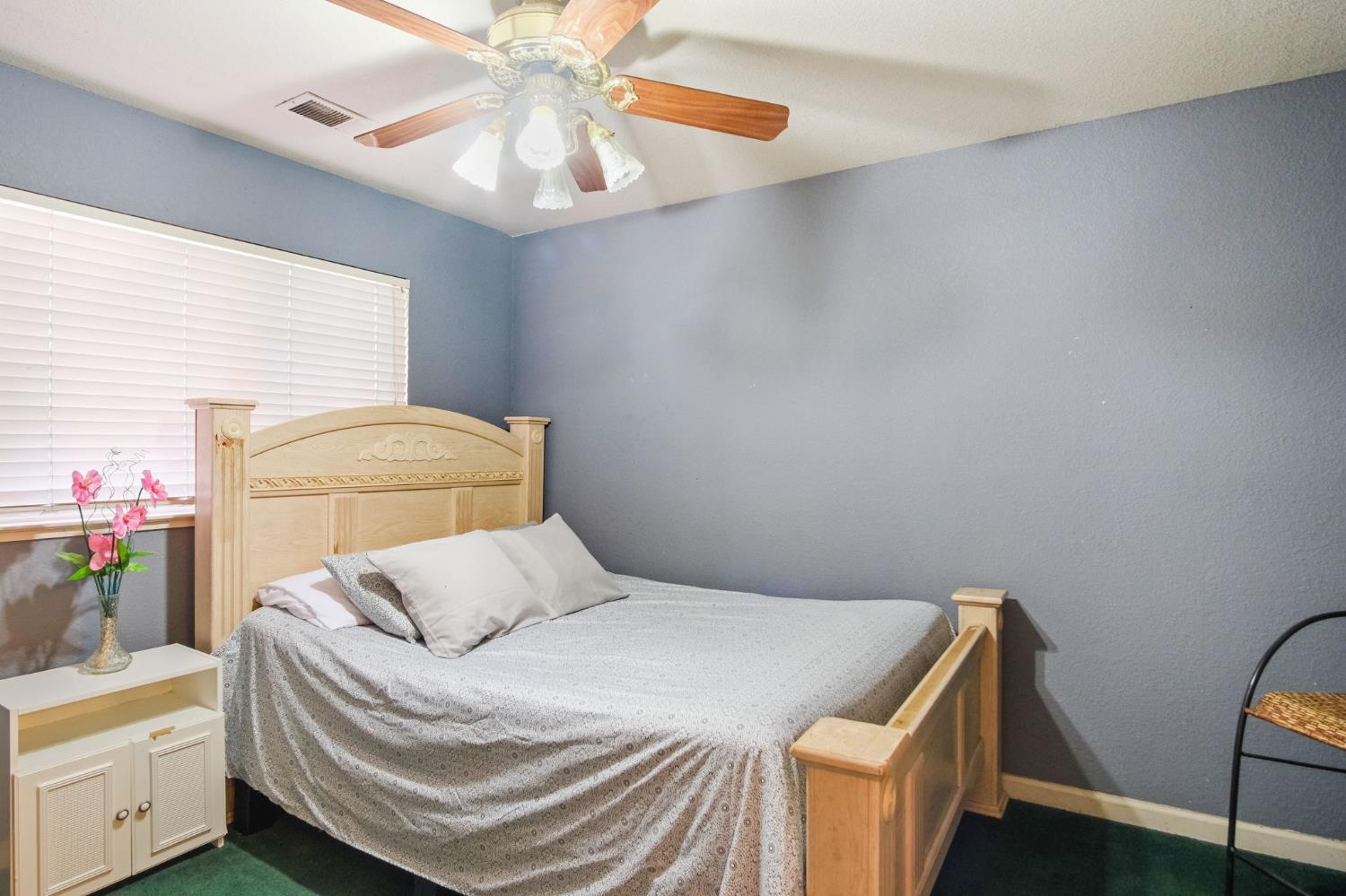 2805 Medinah Way Modesto, CA 95355 - Photo 22 of 39 a bedroom with a bed and a chandelier