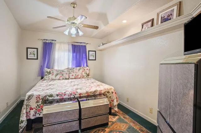 a bedroom with a bed and a flat tv screen on dresser
