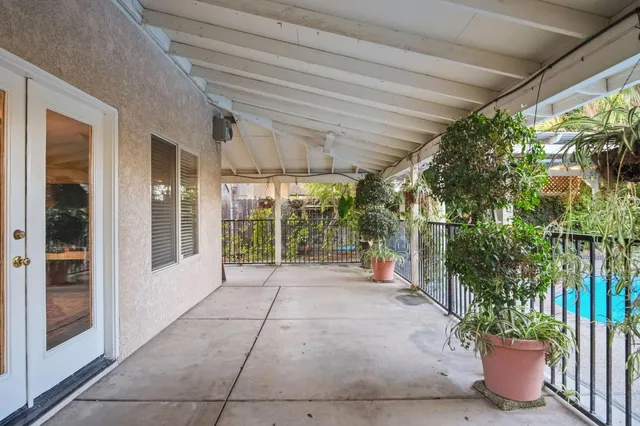 a view of a porch with plants and glass windows