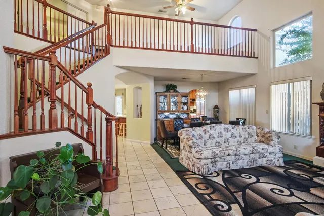 a living room with a bed stairs and a dining table