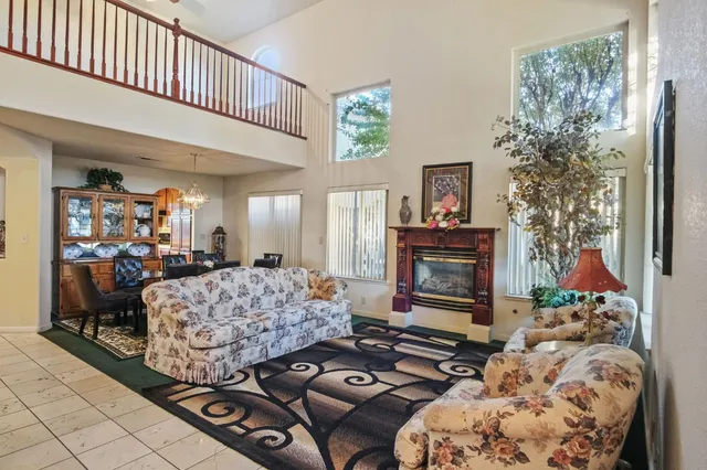 a living room with furniture a fireplace and a chandelier