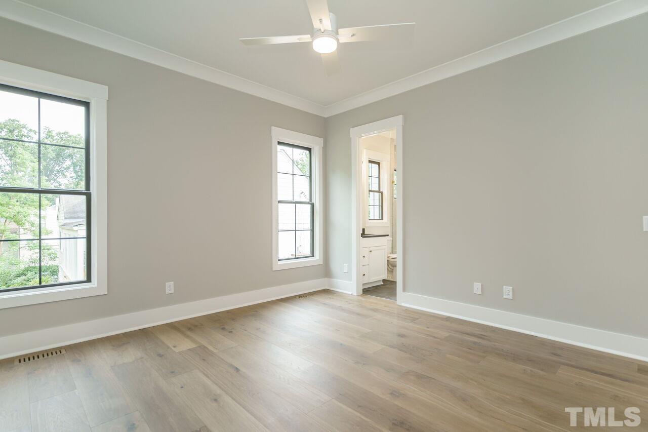 2535 Wake Drive Raleigh, NC 27608 - Photo 23 of 51 an empty room with wooden floor cabinet and windows