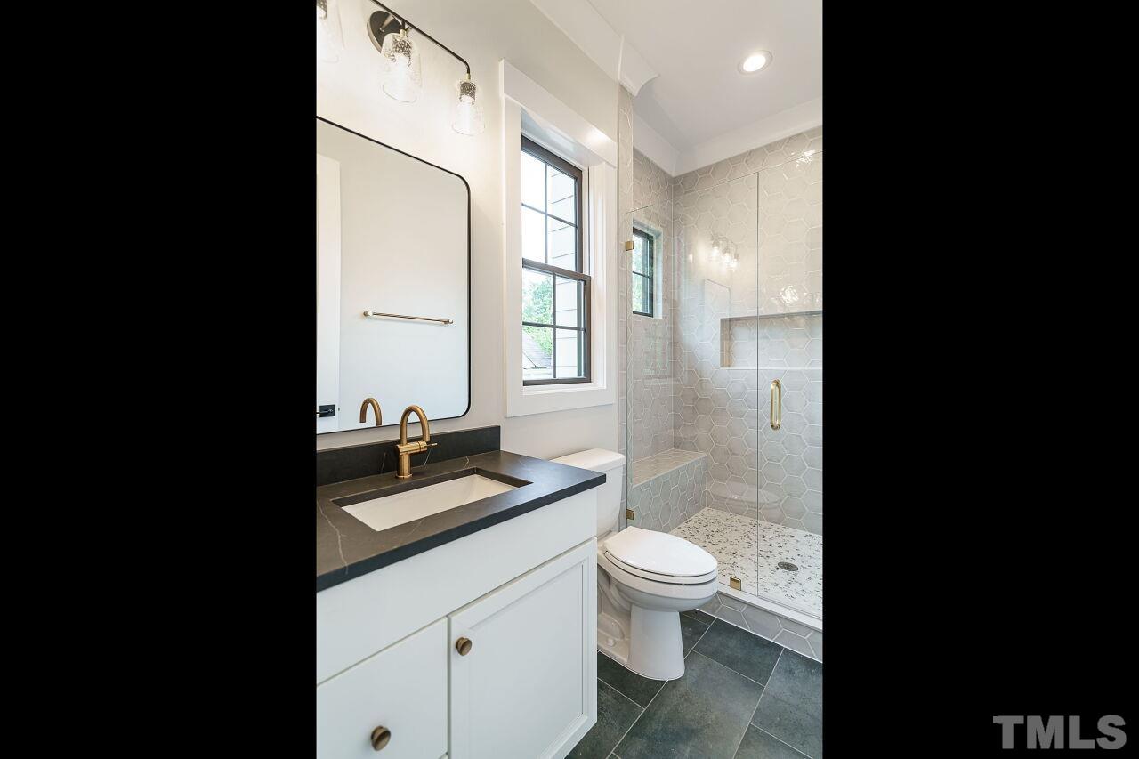 2535 Wake Drive Raleigh, NC 27608 - Photo 24 of 51 a bathroom with a granite countertop toilet sink and mirror