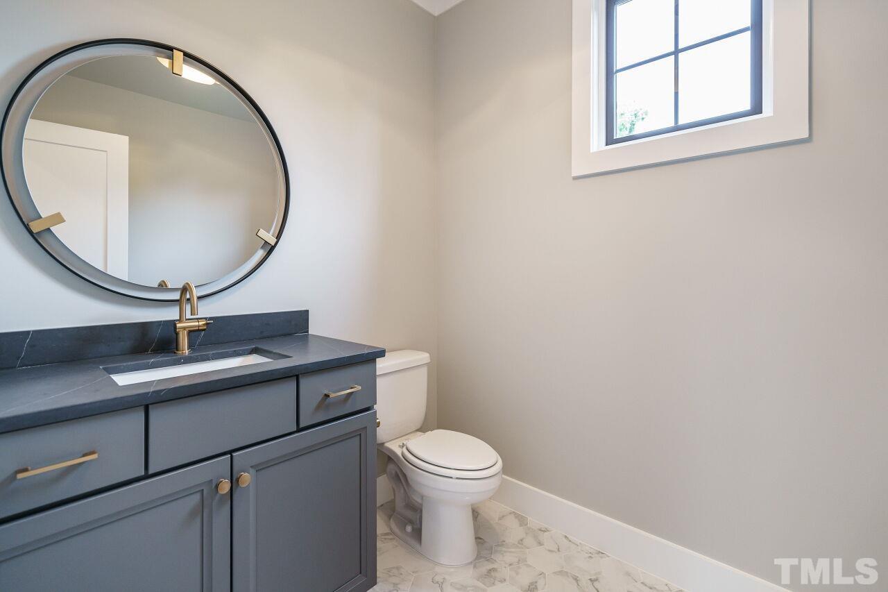 2535 Wake Drive Raleigh, NC 27608 - Photo 41 of 51 a bathroom with a toilet a sink and mirror