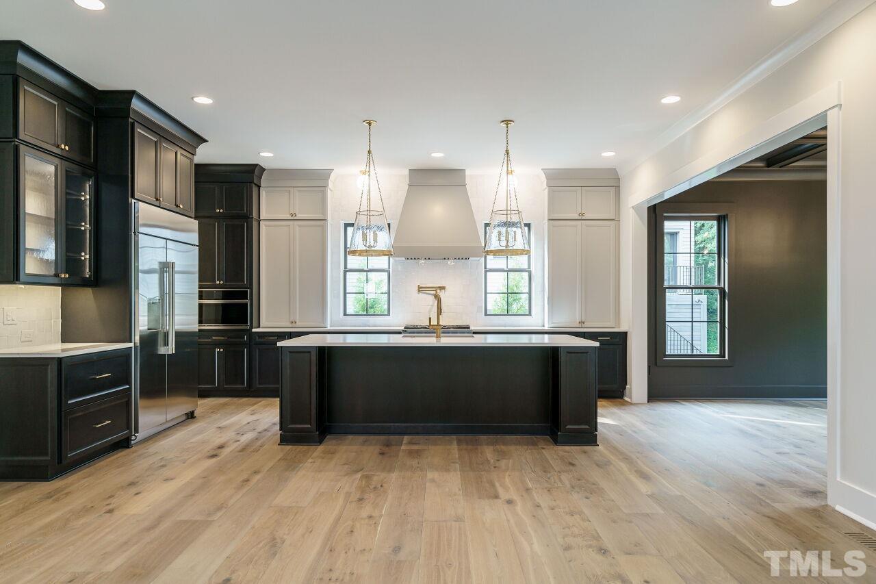 2535 Wake Drive Raleigh, NC 27608 - Photo 10 of 51 a large kitchen with kitchen island granite countertop a refrigerator a sink a stove a dining table and chairs