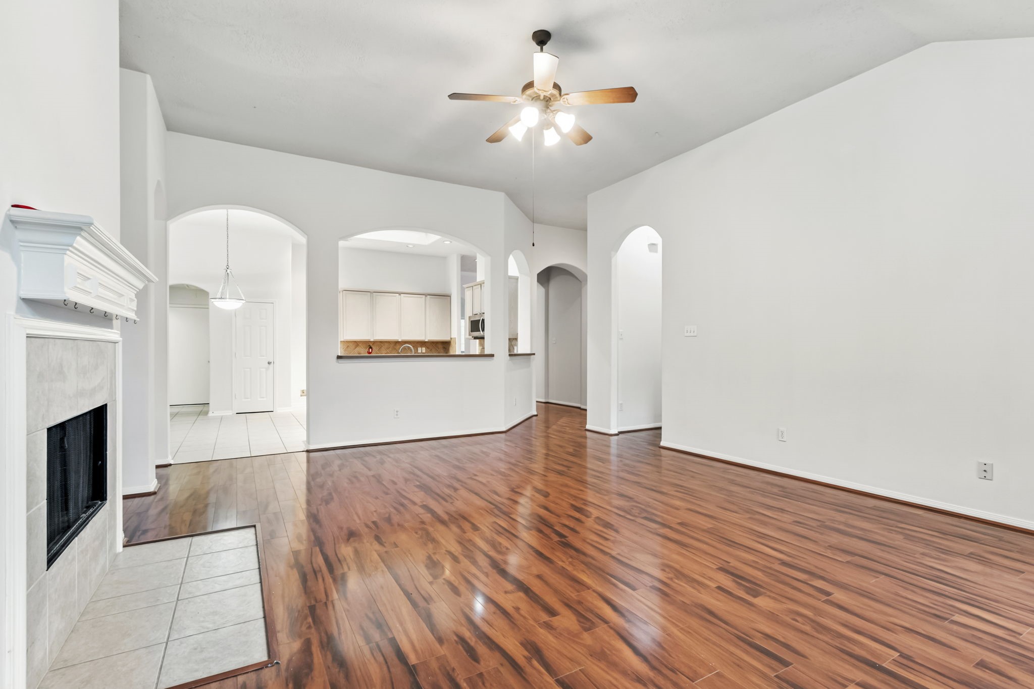 31235 Windcrest Park Lane Spring, TX 77386 - Photo 12 of 50 a view of a livingroom with a fireplace a chandelier and wooden floor