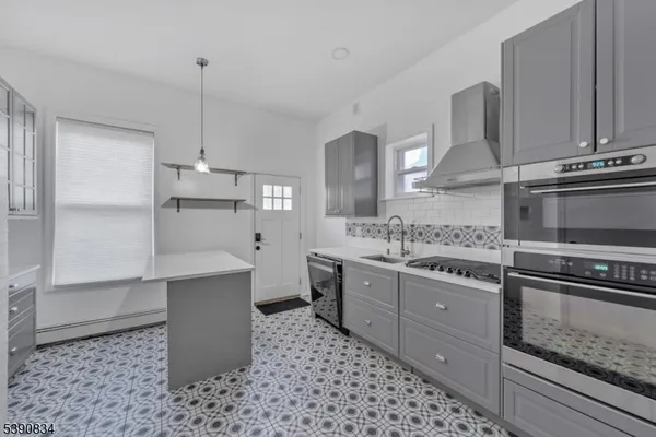 a kitchen with stainless steel appliances kitchen island granite countertop a sink and a stove