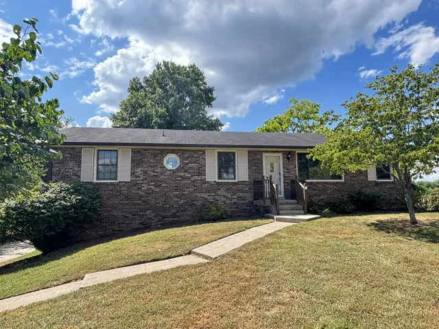a front view of a house with a yard and potted plants
