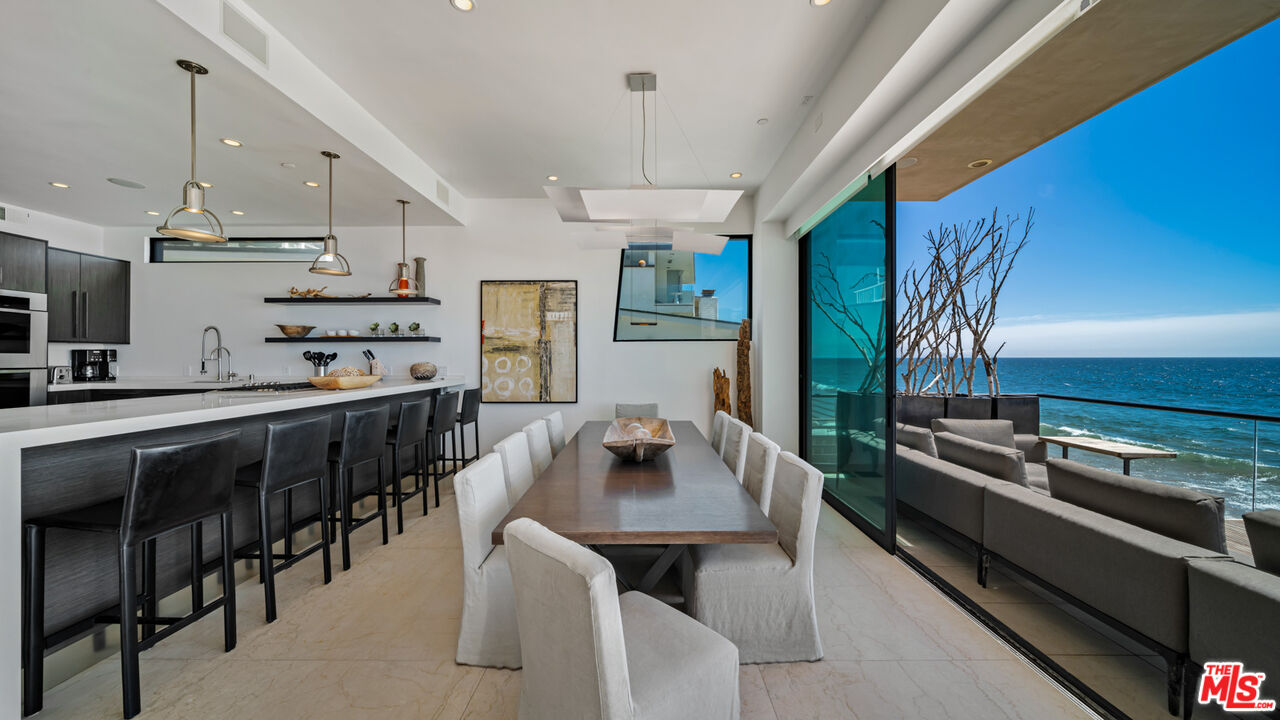 25250 Malibu Road Malibu, CA 90265 - Photo 20 of 66 a kitchen with stainless steel appliances granite countertop a stove a sink dishwasher a dining table and chairs with wooden floor