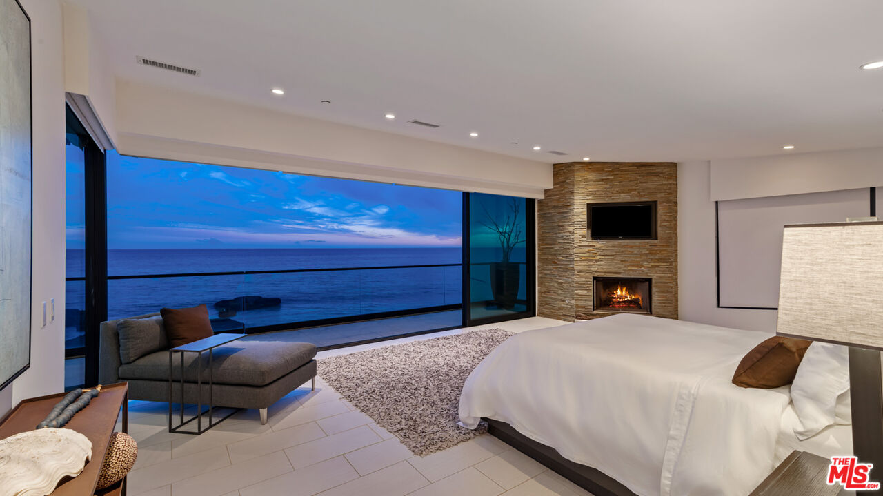 25250 Malibu Road Malibu, CA 90265 - Photo 34 of 66 a spacious bedroom with a bed and a fireplace