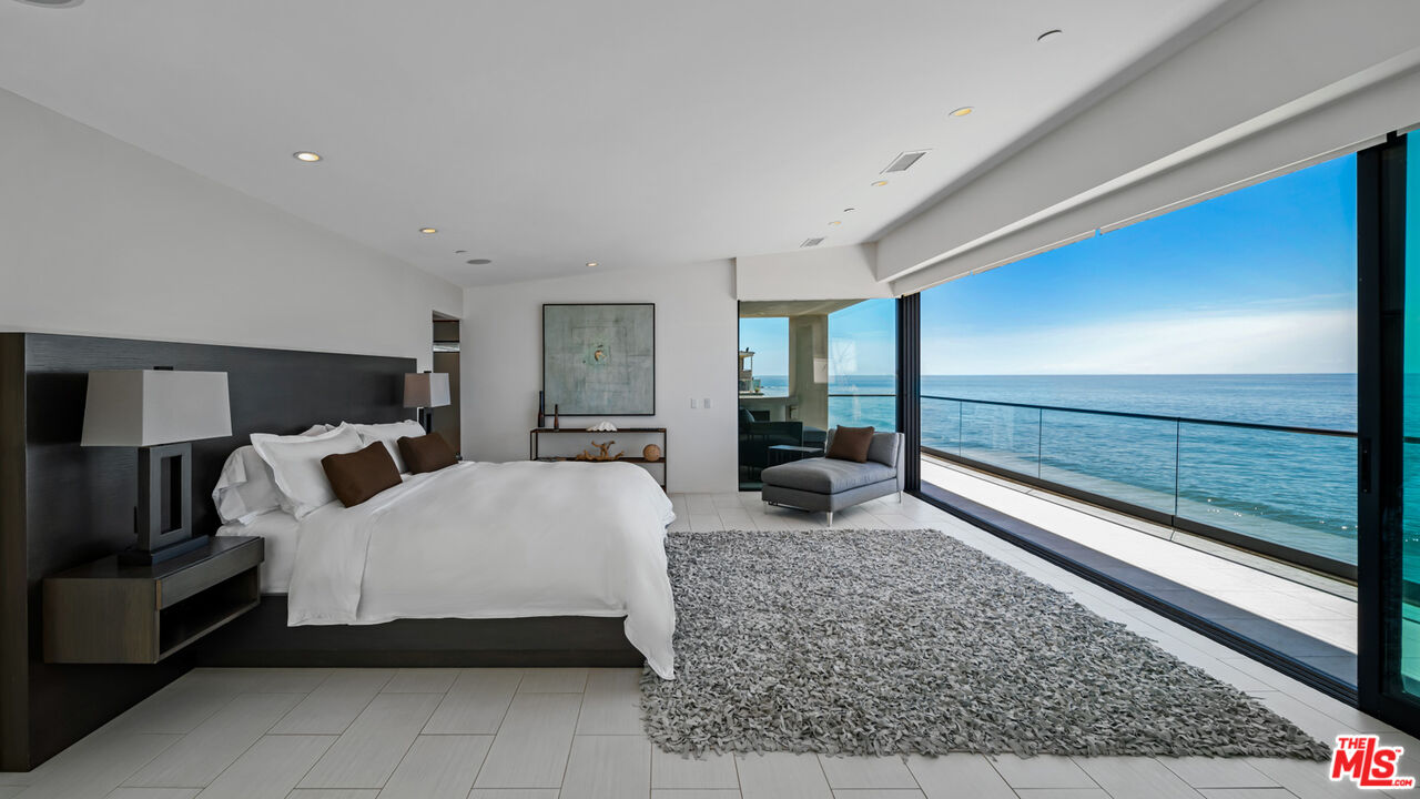 25250 Malibu Road Malibu, CA 90265 - Photo 36 of 66 a spacious bedroom with a bed and large windows