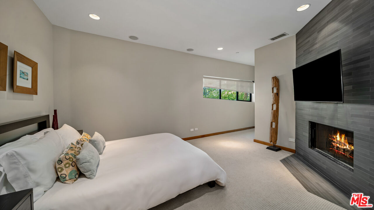 25250 Malibu Road Malibu, CA 90265 - Photo 49 of 66 a bedroom with a bed and a fireplace