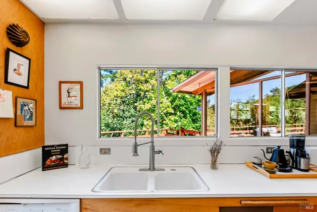 a kitchen with a stove a sink and a window